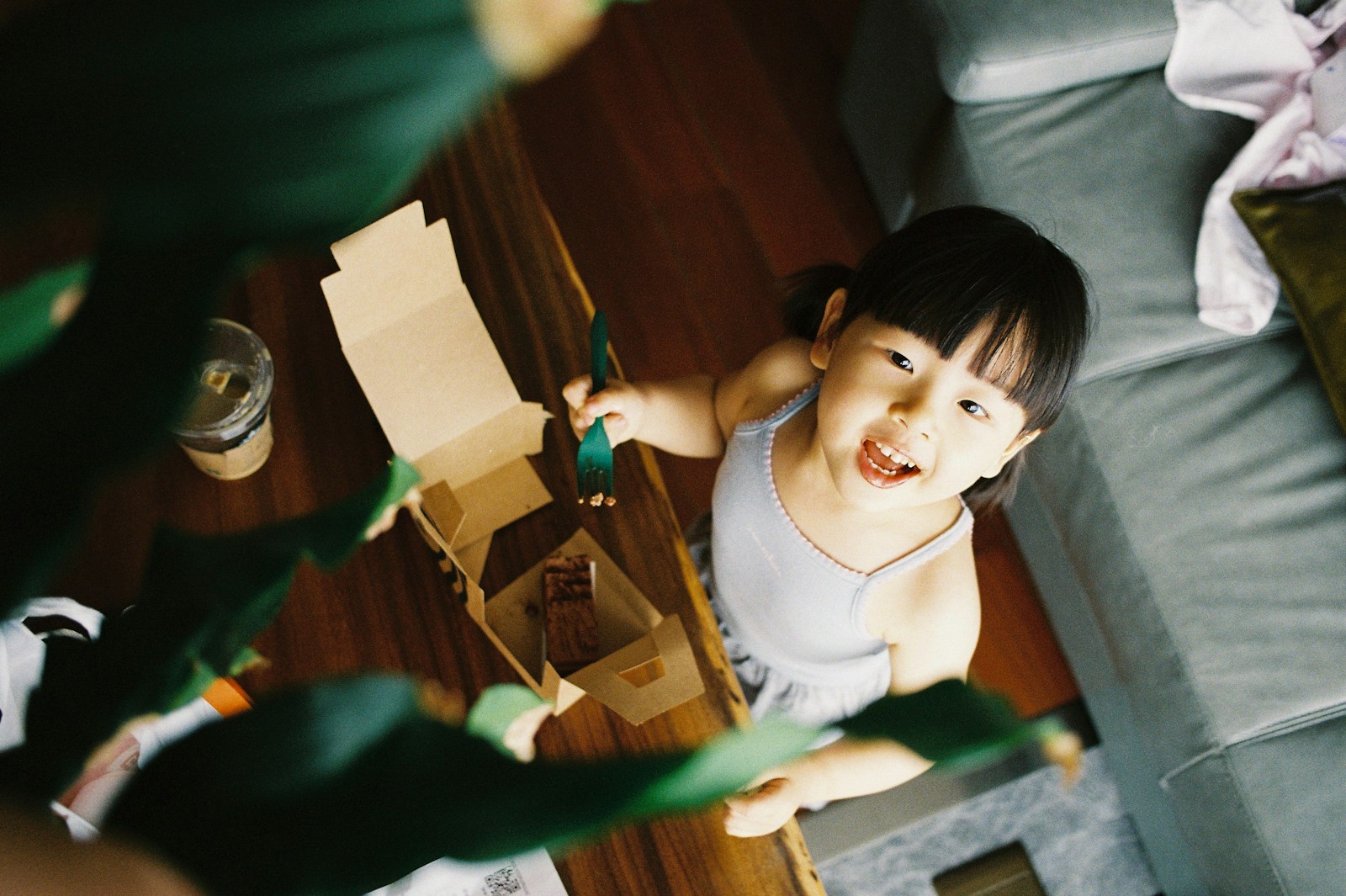 girl in white tank top sitting on brown wooden floor
